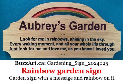 Garden sign with a message and rainbow on it.